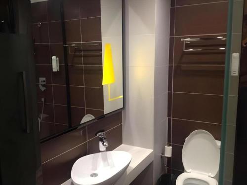 a bathroom with a sink and a toilet and a mirror at 7 Days Inn Zhangjiakou Chongli Yuxing Road in Zhangjiakou