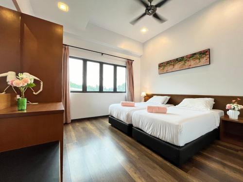 a hotel room with two beds and a window at Nova Mountain n Sunrise view Hilltop Hotel Apartment in Cameron Highlands in Cameron Highlands