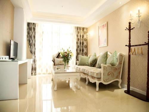 a living room with a couch and a table at GreenTree Alliance Anhui Hefei South Passenger Station South High Speed Railway Station Hotel in Hefei