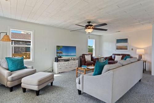 a living room with two couches and a ceiling fan at 4086 - The Wren's Nest in Kitty Hawk