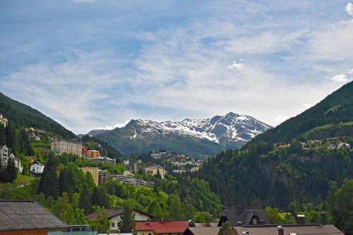 a town in a valley with snow capped mountains at Alpenpension Gastein in Bad Gastein