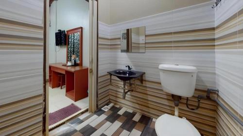 un baño con inodoro y lavabo en OYO 91052 Hotel Kenangan, en Kuala Terengganu