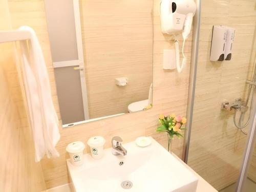 a bathroom with a sink and a mirror at GreenTree Inn JiangSu DingShu Twon JieFang(E) Road Express Hotel in Zhoushu