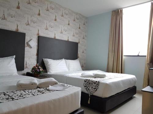 two beds in a hotel room with white walls at City View Hotel At KLIA & KLIA2 in Kuala Lumpur