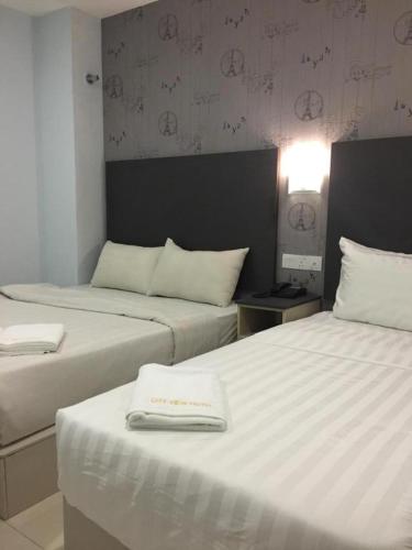 a hotel room with two beds and a lamp at City View Hotel At KLIA & KLIA2 in Kuala Lumpur