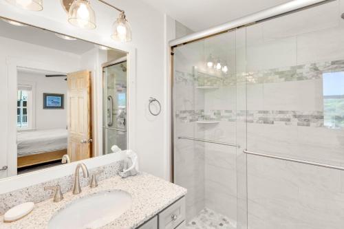a bathroom with a shower and a sink and a mirror at 3018 - Celestial Mermaid in Southern Shores