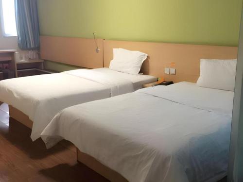 two beds sitting next to each other in a room at 7 Days Inn West Gate of Taiyuan University of Technology in Taiyuan