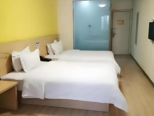 a large white bed in a hotel room at 7 Days Inn West Gate of Taiyuan University of Technology in Taiyuan