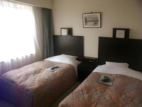 Ένα ή περισσότερα κρεβάτια σε δωμάτιο στο Takada Terminal Hotel