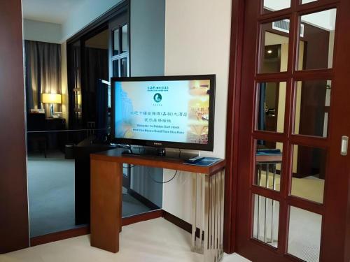 a flat screen tv sitting on a table in a room at Shantou Golden Gulf Hotel in Shantou