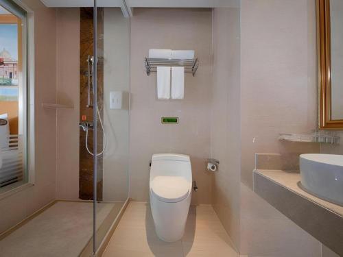 a bathroom with a toilet and a sink and a shower at Vienna Hotel Shenzhen Pinghu Shuangyong Street Metro Station in Tiantangwei