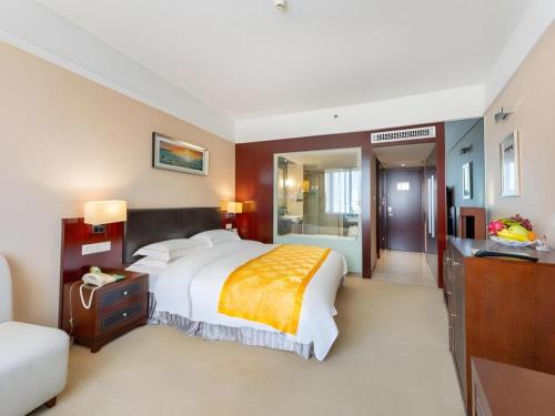 a bedroom with a large bed and a bathroom at Shantou Golden Gulf Hotel in Shantou