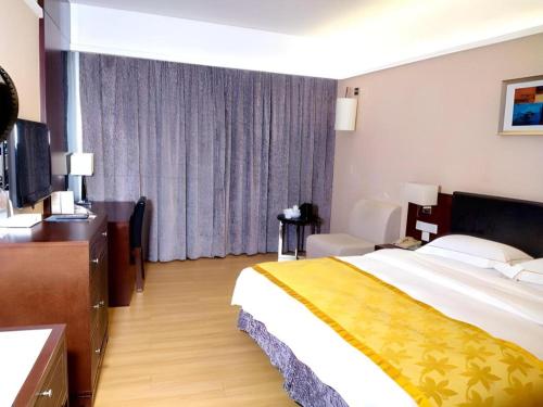 a hotel room with a large bed and a television at Shantou Golden Gulf Hotel in Shantou