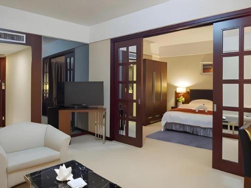 a hotel room with a bed and a television at Shantou Golden Gulf Hotel in Shantou