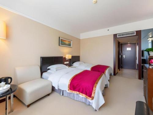 a hotel room with a large bed and a table at Shantou Golden Gulf Hotel in Shantou