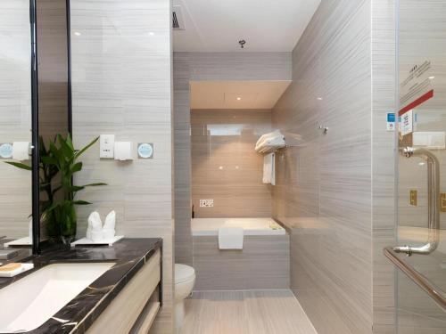 a bathroom with a toilet and a sink and a shower at Huafa Executive Apartment Hotel Zhuhai in Zhuhai