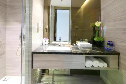 a bathroom with a sink and a mirror at Huafa Executive Apartment Hotel Zhuhai in Zhuhai