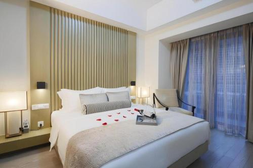 a bedroom with a large white bed with roses on it at Huafa Executive Apartment Hotel Zhuhai in Zhuhai