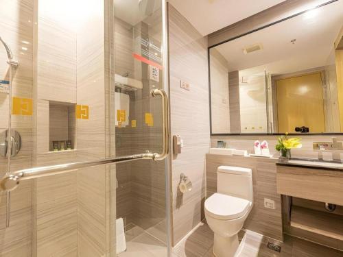 a bathroom with a shower and a toilet and a sink at Huafa Executive Apartment Hotel Zhuhai in Zhuhai