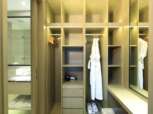 a bathroom with a walk in closet with a mirror at Huafa Executive Apartment Hotel Zhuhai in Zhuhai