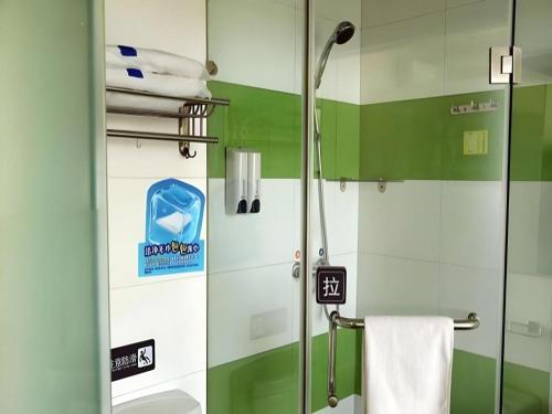 a shower in a bathroom with green and white walls at 7 Days Inn Changchun Zhengyang Street Changchun Park Branch in Changchun