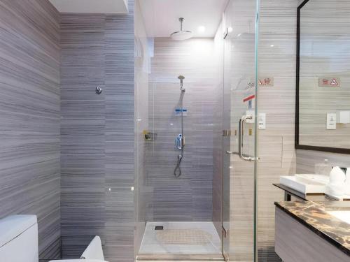 a bathroom with a shower with a glass door at Huafa Executive Apartment Hotel Zhuhai in Zhuhai
