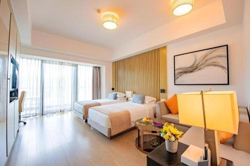 a hotel room with a bed and a couch at Huafa Executive Apartment Hotel Zhuhai in Zhuhai