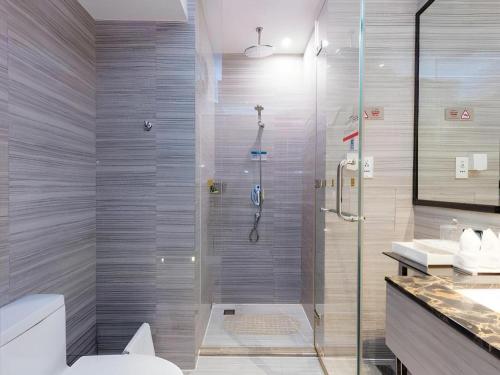a bathroom with a shower with a toilet and a sink at Huafa Executive Apartment Hotel Zhuhai in Zhuhai