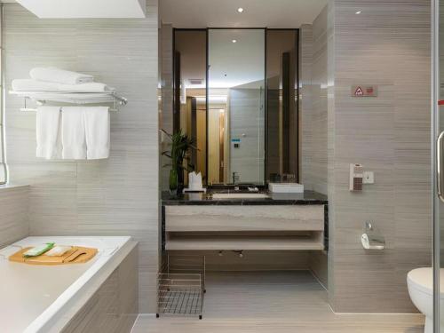 a bathroom with a sink and a mirror at Huafa Executive Apartment Hotel Zhuhai in Zhuhai