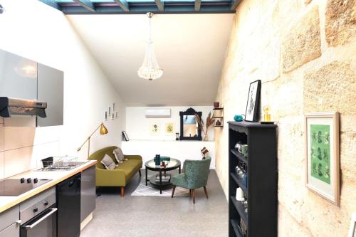 une cuisine et un salon avec un canapé et une table dans l'établissement Beautiful duplex with AC - Place du Palais, à Bordeaux