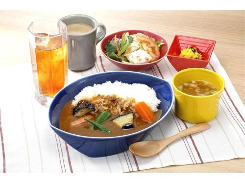 a bowl of soup and rice and a drink on a table at KEIKYU EX INN Keikyu Kawasaki-Station in Kawasaki