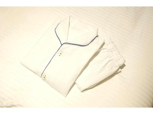 a white shirt sitting on top of a bed at KEIKYU EX INN Keikyu Kawasaki-Station in Kawasaki
