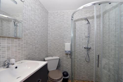 uma casa de banho com um chuveiro, um WC e um lavatório. em Hotel Belledonne em Le Bourg-dʼOisans