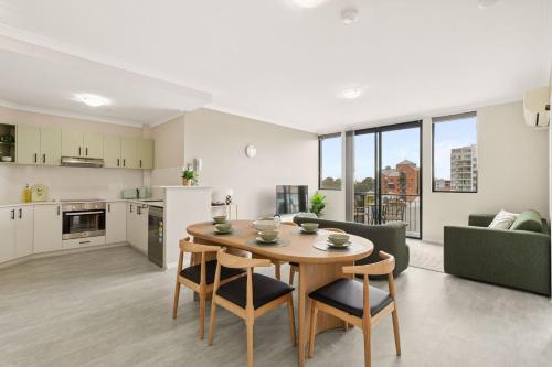 a kitchen and living room with a table and chairs at Spacious Apartment in East Perth - Close to OPTUS Stadium, CBD, WACA in Perth