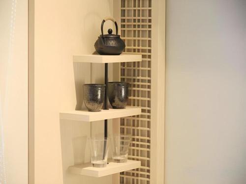 a shelf with glasses and a purse on top of it at Hotel Yaenomidori Tokyo in Tokyo
