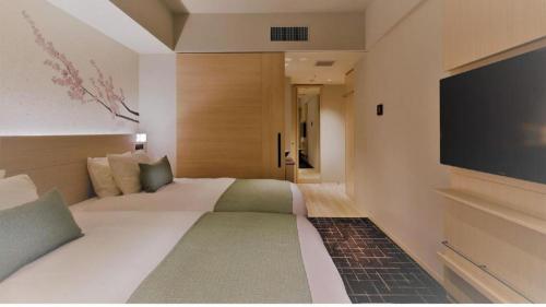 a hotel room with a large bed and a flat screen tv at Hotel Yaenomidori Tokyo in Tokyo