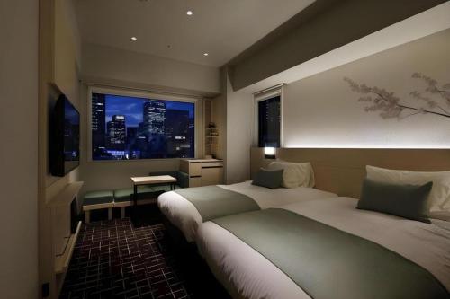 a hotel room with two beds and a window at Hotel Yaenomidori Tokyo in Tokyo