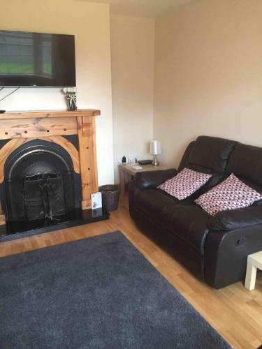 a living room with a couch and a fireplace at 39 woodview in Listowel