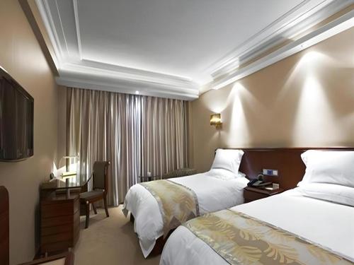 a hotel room with two beds and a television at Ambassador Hotel in Shenzhen