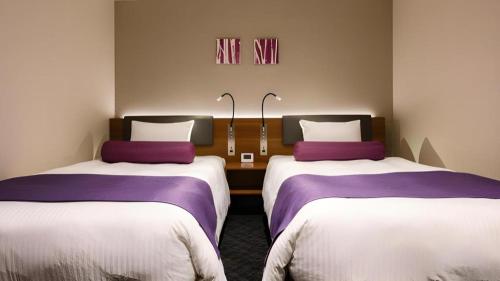 two beds in a room with purple and white sheets at KEIKYU EX INN Haneda Innovation City 2 minutes walk from HICity Exit of Tenkubashi Station in Tokyo