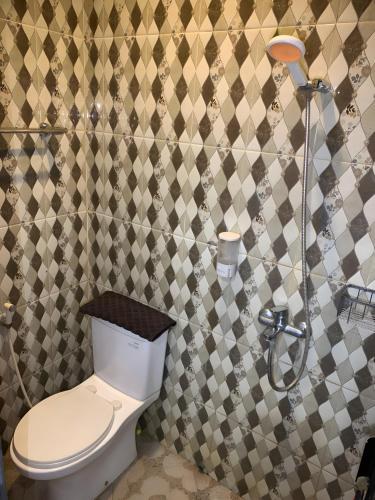 a bathroom with a toilet and a shower at Prime Adisucipto Hotel in Kalasan