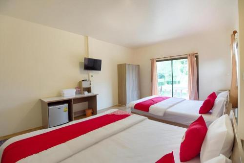 une chambre d'hôtel avec deux lits et une fenêtre dans l'établissement OYO 75359 Thaiburi Thara Resort, à Ban Yan Chao