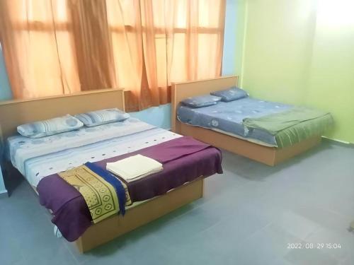 zwei Betten in einem Zimmer mit in der Unterkunft OYO 90471 Hotel Tepoh in Kampong Banggol Binjai