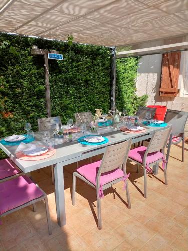 une table avec des chaises, des assiettes et des verres dans l'établissement Jadis sous la gloriette, à Sancoins