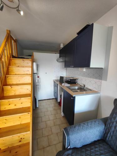 une cuisine avec des armoires noires et un comptoir dans l'établissement Quiet studio with terrace near the sea, à La Seyne-sur-Mer