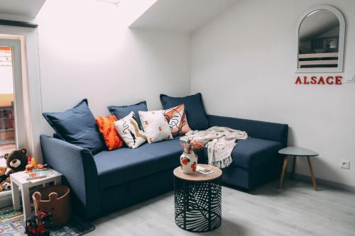 un salon avec un canapé bleu et une table dans l'établissement Gîte à la ferme, à Appenwihr