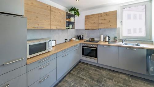 a kitchen with stainless steel appliances and wooden cabinets at Ferienwohnung Rottweil Zentrum - Parkplatz kostenlos in Rottweil