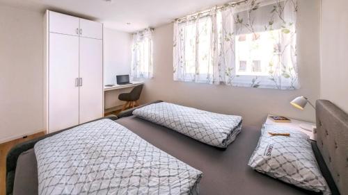 a bedroom with two beds and a desk at Ferienwohnung Rottweil Zentrum - Parkplatz kostenlos in Rottweil