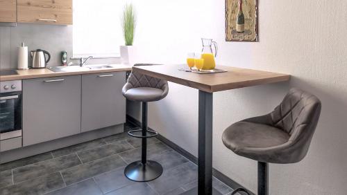 a kitchen with a table and two bar stools at Ferienwohnung Rottweil Zentrum - Parkplatz kostenlos in Rottweil