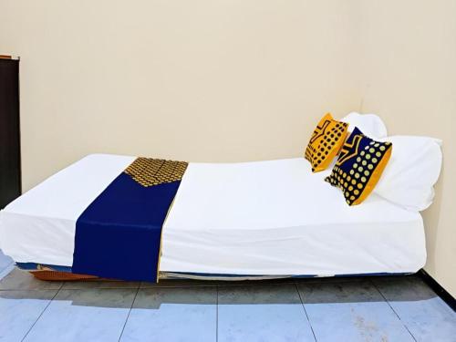 a bed with two ties sitting on top of it at Homely Syariah in Kediri